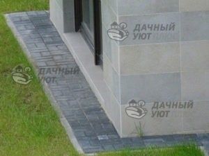Фото 7 –Отмостка из бручсатки, сделанная вокруг стен дома, защищает их от брызг, но не препятствует испарению грунтовой влаги.
